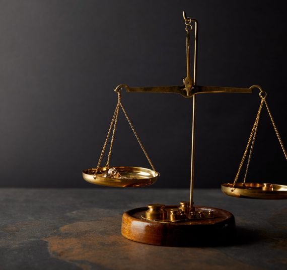 golden stones on scales on marble table and dark background